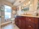 Bathroom vanity with granite countertop, modern lighting, wood cabinets, and tile flooring at 7851 120Th St, Seminole, FL 33772