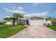 Charming single-story home featuring a two-car garage, lush lawn, and mature palm trees at 7851 120Th St, Seminole, FL 33772
