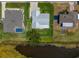 Aerial shot of a home with metal roof, green lawn, and water view showcasing the property's layout at 817 Eagle Ln, Apollo Beach, FL 33572