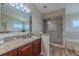 Bright bathroom featuring a glass enclosed shower, granite countertops, and wood look tile flooring at 817 Eagle Ln, Apollo Beach, FL 33572