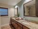 Bright bathroom with dual sinks, granite countertops, and wood look tile flooring at 817 Eagle Ln, Apollo Beach, FL 33572