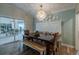 Dining room with large chandelier, bench seating, and sliding glass doors to the patio at 817 Eagle Ln, Apollo Beach, FL 33572