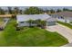 Beautifully landscaped single-story home with a well-manicured lawn, a metal roof, and a large driveway at 817 Eagle Ln, Apollo Beach, FL 33572