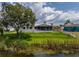 Charming home featuring a screened lanai, lush backyard, and peaceful water view creating a serene living space at 817 Eagle Ln, Apollo Beach, FL 33572