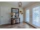 Elegant foyer with decorative glass double doors, wood-look tile flooring, and stylish decor at 817 Eagle Ln, Apollo Beach, FL 33572