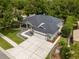 Aerial view of home showcasing well-maintained landscaping, concrete driveway, and a two-car garage at 8401 Ashford Pl, Trinity, FL 34655