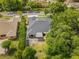 A home with a backyard and patio, surrounded by tall hedges and large trees in a quiet neighborhood at 8401 Ashford Pl, Trinity, FL 34655