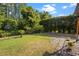 Spacious backyard with lush green grass, a black chain-link fence, and well-manicured landscaping at 8401 Ashford Pl, Trinity, FL 34655