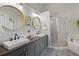 Elegant bathroom with dual sinks, stylish mirrors, and a glass-enclosed shower at 8401 Ashford Pl, Trinity, FL 34655