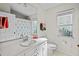 Bright bathroom featuring a white vanity, toilet, mirror, and a window for natural light at 8401 Ashford Pl, Trinity, FL 34655