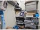 Organized closet with shelving, featuring storage containers, linens, and an ironing board at 8401 Ashford Pl, Trinity, FL 34655