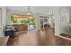 Open living room with hardwood floors, glass doors to outdoor living space, and a jacuzzi at 8401 Ashford Pl, Trinity, FL 34655