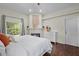 Comfortable main bedroom with a decorative fireplace, large windows, and hardwood flooring at 8401 Ashford Pl, Trinity, FL 34655