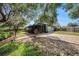 Spacious backyard with brick paver patio, mature trees, lawn, and a screened-in porch for outdoor enjoyment at 8517 Woodwick Ct, Tampa, FL 33615