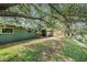 Backyard of green house features manicured lawn, and mature trees along a waterway at 8517 Woodwick Ct, Tampa, FL 33615