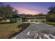 Inviting single-story home featuring a long driveway, lush lawn, and tasteful landscaping with a unique dark green exterior at 8517 Woodwick Ct, Tampa, FL 33615