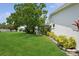 Beautifully landscaped backyard with lush lawn, covered patio, and mature trees for shade at 9018 39Th N Ln # 5, Pinellas Park, FL 33782