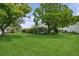 Lush backyard with expansive green lawn, mature trees, and partial view of the home at 9018 39Th N Ln # 5, Pinellas Park, FL 33782
