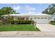 Charming single-story home featuring a well-manicured lawn, vibrant flowers, and a two-car garage at 9018 39Th N Ln # 5, Pinellas Park, FL 33782