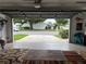 View from the garage looking out onto the drive and neighborhood, with carpets on the floor at 9018 39Th N Ln # 5, Pinellas Park, FL 33782