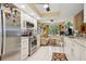 Bright kitchen with white cabinets, stainless steel appliances and view to Gathering room at 9018 39Th N Ln # 5, Pinellas Park, FL 33782