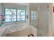 Bathroom featuring a soaking tub with a unique stained glass window and separate glass shower at 934 Lucas Ln, Oldsmar, FL 34677