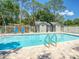Community pool with clear water, pool ladder, surrounded by lush landscaping, ideal for relaxation and exercise at 934 Lucas Ln, Oldsmar, FL 34677