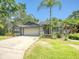 Charming home featuring lush landscaping, a well-maintained lawn, and a two-car garage at 934 Lucas Ln, Oldsmar, FL 34677