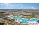 Expansive aerial view showcasing a Primary-planned community with a large lagoon, surrounding neighborhoods, and convenient access to amenities at 10217 Trumpet Honeysuckle Way, San Antonio, FL 33576