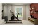 Functional home gym setup with weights, exercise bike, wall shelves, and neutral decor for a motivating workout space at 10270 Purple Leaf Ct, Riverview, FL 33578