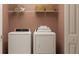 Functional laundry room with a washer, dryer, shelving, and storage baskets at 10270 Purple Leaf Ct, Riverview, FL 33578