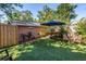 Backyard featuring green turf, lounge chairs, hammock, shade umbrella, and tropical landscaping at 1174 8Th N St, St Petersburg, FL 33701