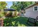 Backyard oasis featuring green turf, lounge chairs, hammock, shade umbrella, and a stock tank pool at 1174 8Th N St, St Petersburg, FL 33701