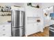 Well-lit kitchen with stainless steel refrigerator, white cabinets, and modern appliances at 1174 8Th N St, St Petersburg, FL 33701