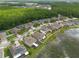 Aerial view of houses near a lake, with lush tree coverage and a clear blue sky at 12352 Crestridge Loop, New Port Richey, FL 34655
