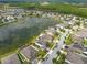 Aerial view of houses near a lake, with lush tree coverage and a clear blue sky at 12352 Crestridge Loop, New Port Richey, FL 34655