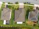 An aerial view of three homes showcasing well-manicured lawns, mature landscaping, and backyard privacy fencing at 12352 Crestridge Loop, New Port Richey, FL 34655