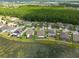 Aerial view of houses near a lake, with lush tree coverage and a clear blue sky at 12352 Crestridge Loop, New Port Richey, FL 34655