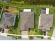 Aerial view of three adjacent homes in a neighborhood, showcasing their driveways, landscaping, and roof styles at 12352 Crestridge Loop, New Port Richey, FL 34655