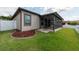 Well-maintained backyard featuring a screened-in lanai, lake view, and white picket fence at 12352 Crestridge Loop, New Port Richey, FL 34655