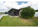 Well-maintained backyard featuring a screened-in lanai, lake view, and lush landscaping at 12352 Crestridge Loop, New Port Richey, FL 34655
