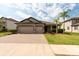 Charming home featuring a brick driveway, a two-car garage, and well-manicured landscaping at 12352 Crestridge Loop, New Port Richey, FL 34655