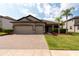 Charming home featuring a brick driveway, a two-car garage, and well-manicured landscaping at 12352 Crestridge Loop, New Port Richey, FL 34655