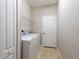 Clean laundry room featuring a modern washer and dryer, tile flooring, and wire rack shelving at 12352 Crestridge Loop, New Port Richey, FL 34655