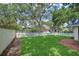 Spacious, grassy backyard enclosed by a charming white picket fence and privacy wall, perfect for outdoor enjoyment at 124 Barrington Dr, Brandon, FL 33511