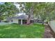 Spacious backyard featuring lush green grass, mature trees, a screened-in pool, and a white picket fence at 124 Barrington Dr, Brandon, FL 33511