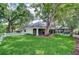 Expansive backyard features lush lawn, mature trees, white picket fence, and screened-in pool area at 124 Barrington Dr, Brandon, FL 33511