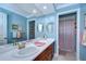 Bathroom features blue walls, white countertop, wood cabinets, and decorative mirrors at 124 Barrington Dr, Brandon, FL 33511