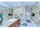 Bathroom features tropical wallpaper, granite countertop, and wood cabinets at 124 Barrington Dr, Brandon, FL 33511