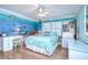 Bright bedroom with coastal mural, ceiling fan, white furniture, and wood floors at 124 Barrington Dr, Brandon, FL 33511